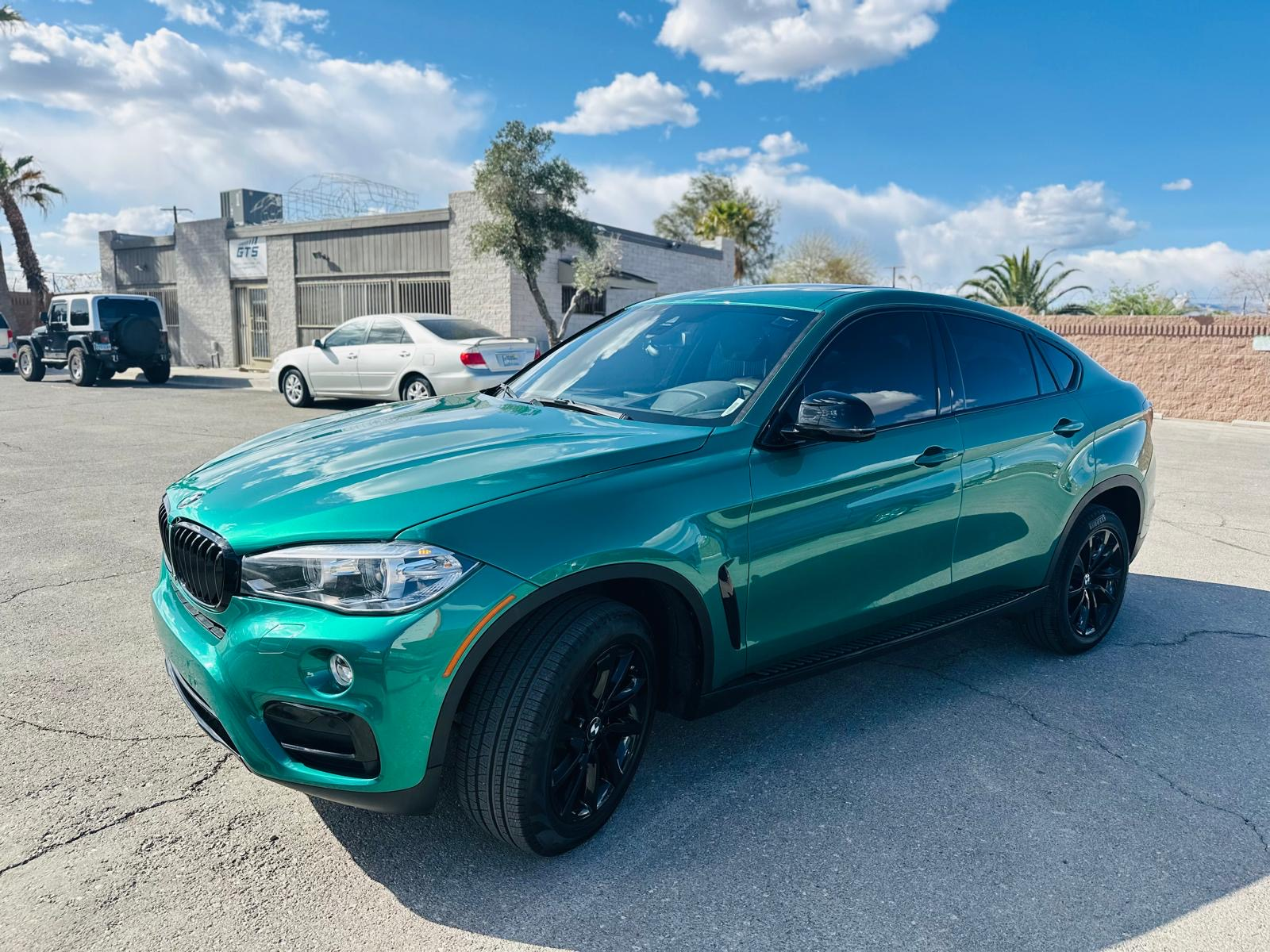 BMW X6 with custom emerald green color change and gloss black wheels